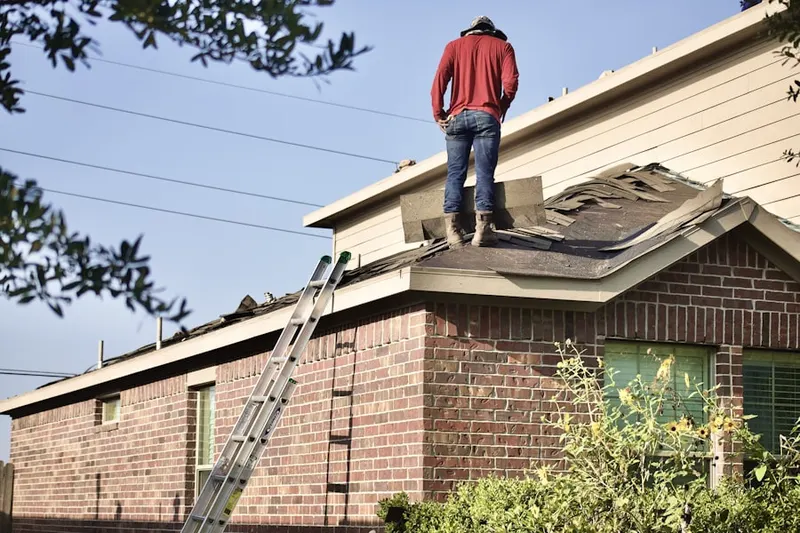 Professional roofer working on a residential roof in Woodbury Gardens